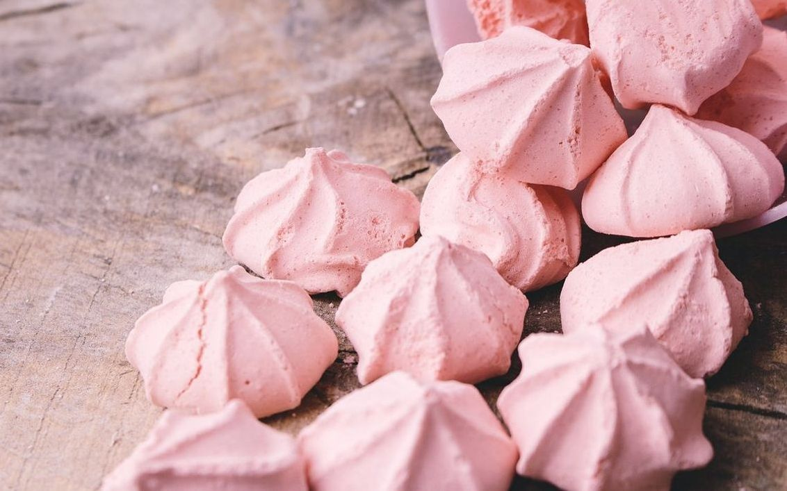 A single raspberry cream fudge square, dusted with icing sugar